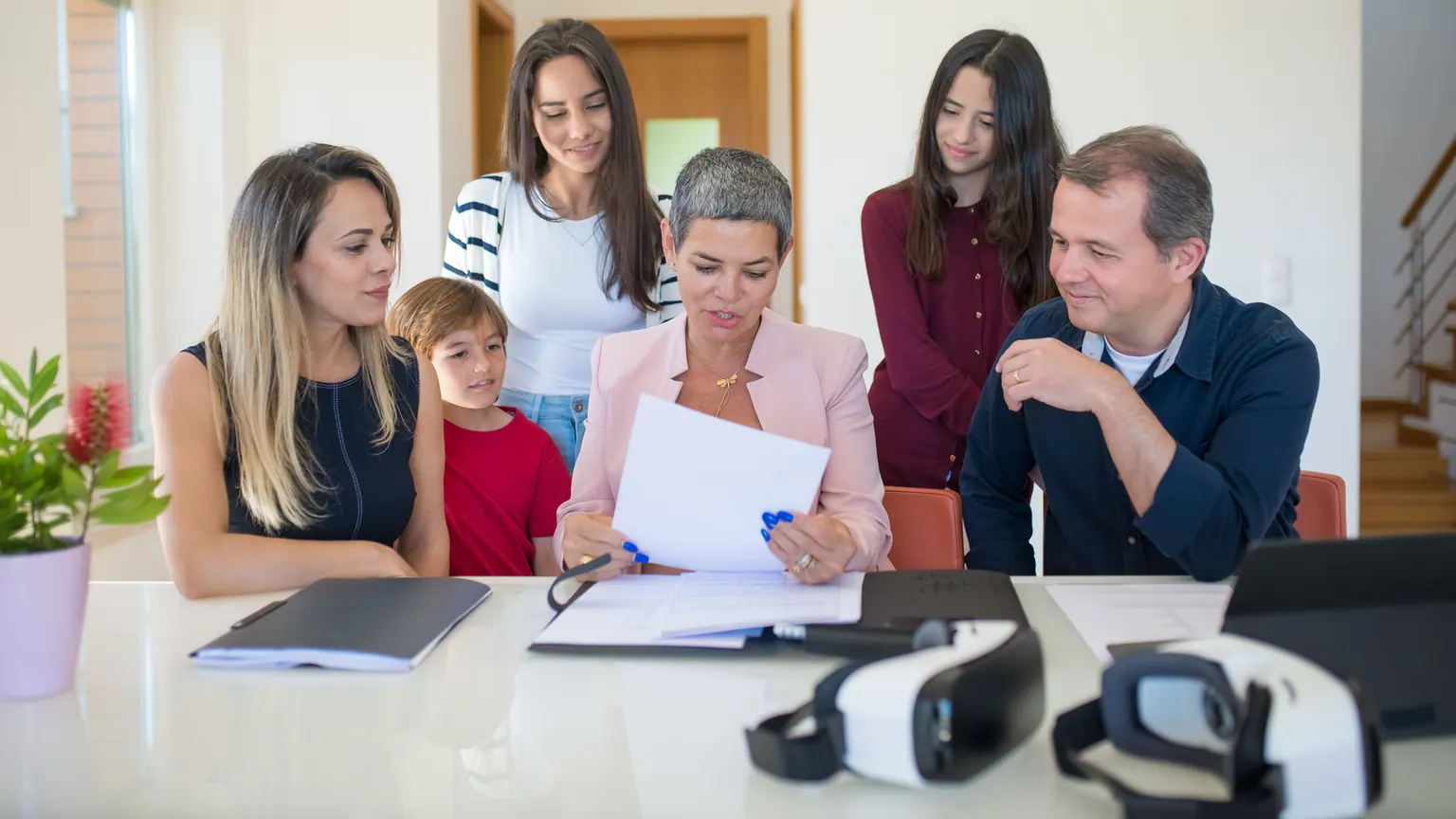 Família e equipe escolar analisam um documento durante uma reunião
