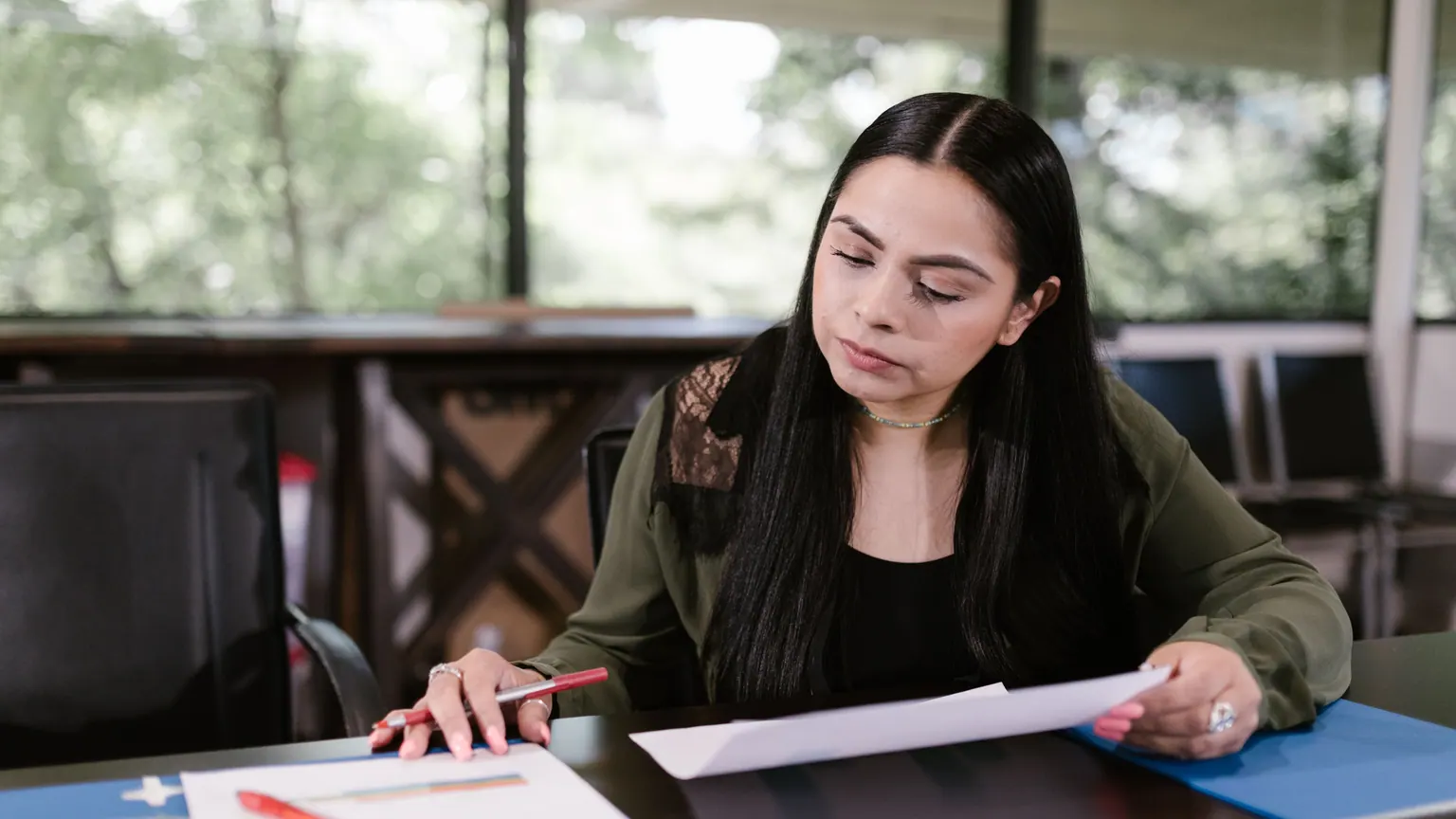 Profissional confere documentos em uma mesa de trabalho